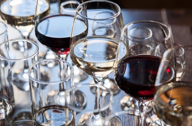 Poured glasses of red and white wine on a tasting table